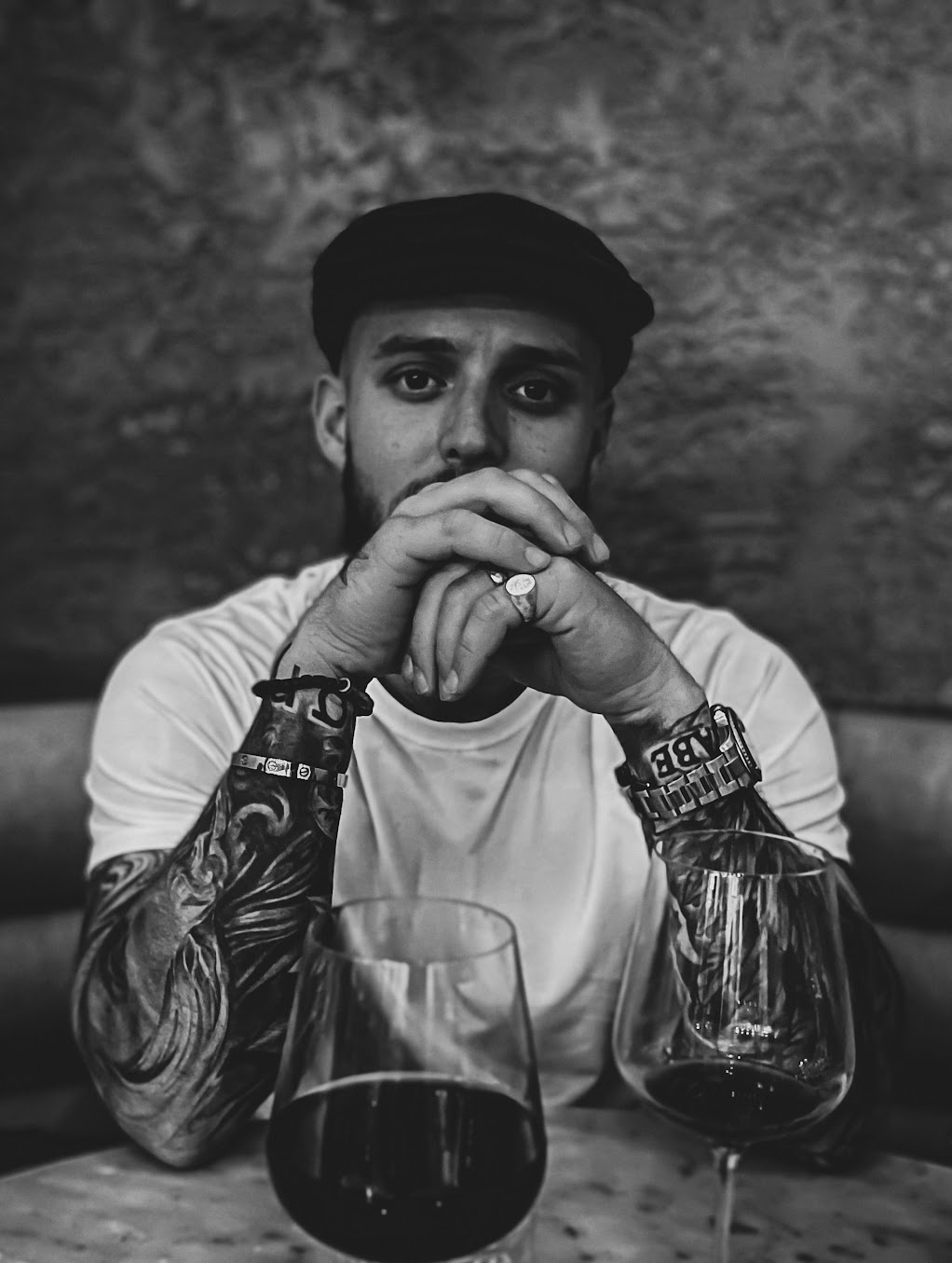 Portrait of the author sitting at a table with two glasses of wine